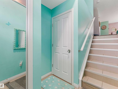 Staircase featuring tiled steps, a white handrail, and white baseboards - 44 1140 Chappelle Boulevard, Edmonton, AB - Indoor Photo Showing Other Room