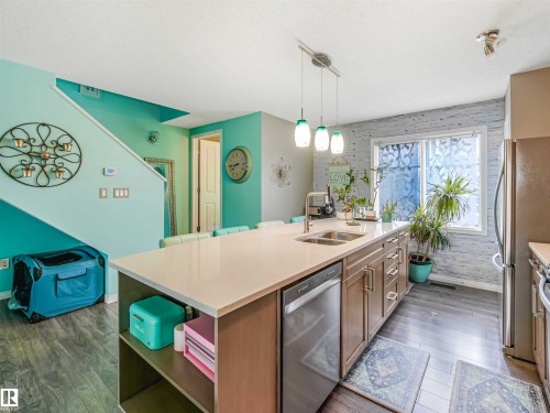 Contemporary kitchen featuring a large island with an undermount double sink and breakfast bar seating - 44 1140 Chappelle Boulevard, Edmonton, AB - Indoor Photo Showing Kitchen With Double Sink