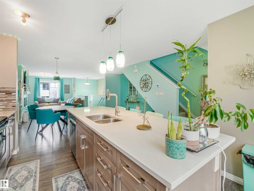 Modern kitchen island with a double basin sink, gooseneck faucet, and integrated dishwasher - 44 1140 Chappelle Boulevard, Edmonton, AB - Indoor Photo Showing Kitchen With Double Sink With Upgraded Kitchen