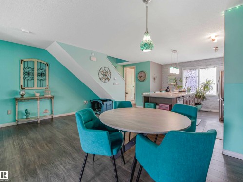 Open-concept living space featuring wood-finish flooring, a contemporary kitchen island, and a bright window - 44 1140 Chappelle Boulevard, Edmonton, AB - Indoor Photo Showing Dining Room