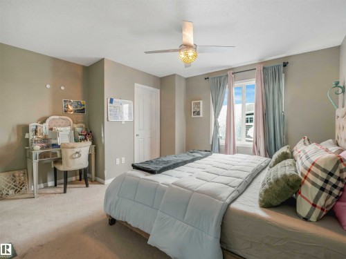 Bedroom featuring a window with natural light, a ceiling fan with integrated lighting, neutral wall paint, and a white paneled door - 44 1140 Chappelle Boulevard, Edmonton, AB - Indoor Photo Showing Bedroom
