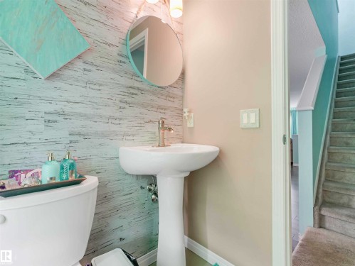 Pedestal sink with a brushed nickel faucet, complemented by a distressed wood-finish accent wall - 44 1140 Chappelle Boulevard, Edmonton, AB - Indoor Photo Showing Bathroom