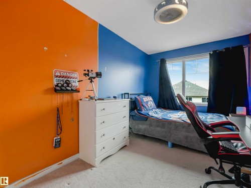 Room featuring a window with black curtains, a ceiling light fixture, and carpeting - 44 1140 Chappelle Boulevard, Edmonton, AB - Indoor Photo Showing Bedroom