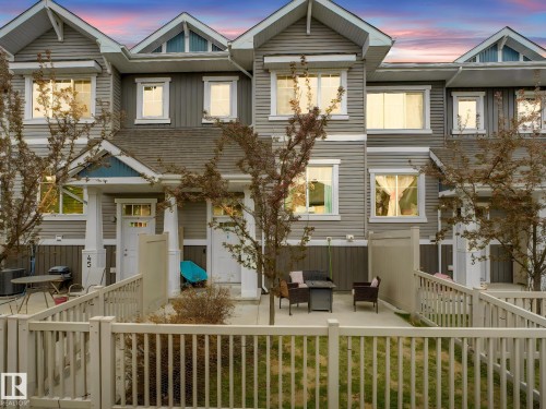 Townhouse exterior featuring gray siding, white trim, and a gabled roofline - 44 1140 Chappelle Boulevard, Edmonton, AB - Outdoor With Facade