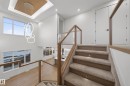 Multi-level interior featuring a contemporary chandelier, recessed lighting, wood-finish flooring, and glass panel railings with wood-finish tops - 4276 Charles Close, Edmonton, AB  - Indoor Photo Showing Other Room 