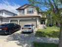Two-story residence featuring light-colored siding, a prominent arched window, and an attached two-car garage - 6116 53 Avenue, Beaumont, AB  - Outdoor With Exterior 