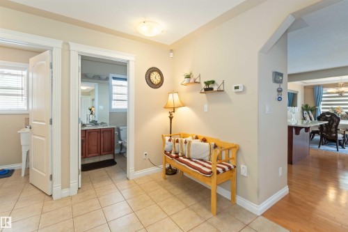 Tile flooring entry with a full bathroom and an arched doorway to a wood-finish flooring area - 6116 53 Avenue, Beaumont, AB - Indoor Photo Showing Other Room