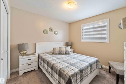 Carpeted room with a window featuring horizontal blinds and a ceiling-mounted light fixture - 6116 53 Avenue, Beaumont, AB - Indoor Photo Showing Bedroom