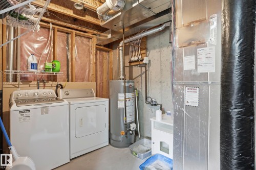 Dedicated utility area featuring a water heater, furnace, and laundry appliances - 14017 156 Avenue, Edmonton, AB - Indoor
