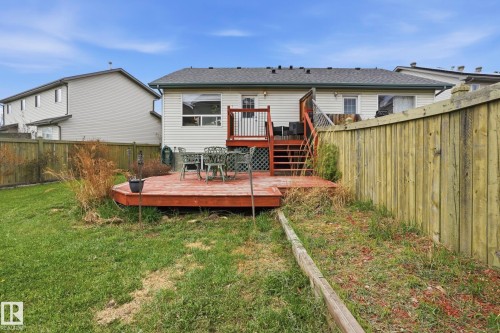 Rear exterior featuring a spacious wood deck, white vinyl siding, and a multi-level staircase - 14017 156 Avenue, Edmonton, AB - Outdoor With Deck Patio Veranda