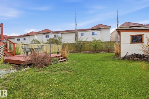 Expansive green lawn with a dedicated wood deck, wood privacy fencing, and a built-in outdoor shed - 14017 156 Avenue, Edmonton, AB - Outdoor