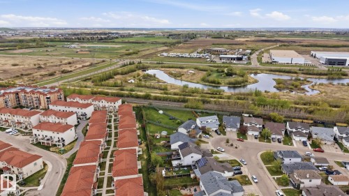 Aerial perspective showcasing a residential community with red-tiled townhomes and single-family residences - 14017 156 Avenue, Edmonton, AB - Outdoor With View