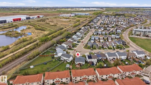 Aerial perspective showcasing a residential neighborhood with detached homes and townhomes, featuring a mix of grey and terracotta rooflines - 14017 156 Avenue, Edmonton, AB - Outdoor With View