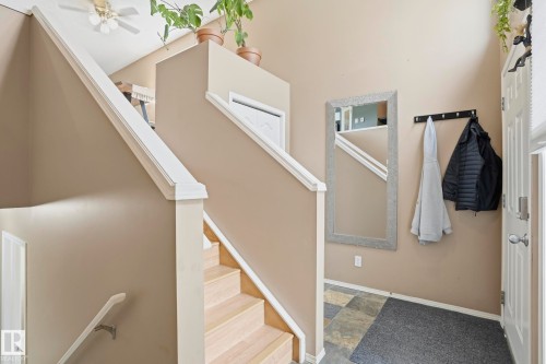 Two-story entry foyer featuring a light wood-finish staircase with white trim, neutral wall tones, and a ceiling fan - 14017 156 Avenue, Edmonton, AB - Indoor Photo Showing Other Room