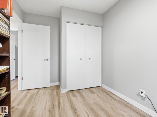 Wood-finish flooring throughout, complemented by light grey wall tones and white baseboards - 18627 62A Avenue, Edmonton, AB - Indoor Photo Showing Other Room