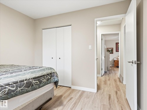 Light wood-finish flooring throughout, featuring a white bi-fold closet and neutral wall paint - 18627 62A Avenue, Edmonton, AB - Indoor Photo Showing Bedroom