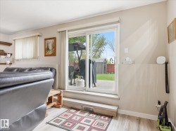 Sliding glass door opening to an outdoor patio with a manicured lawn and garden shed - 
