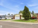 Single-story residence featuring a two-car garage with a white door, yellow siding, and a partial brick facade - 18627 62A Avenue, Edmonton, AB  - Outdoor 