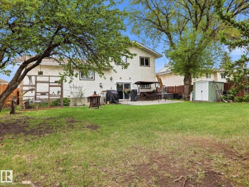 Expansive green lawn with mature trees and a rear stucco exterior - 18627 62A Avenue, Edmonton, AB - Outdoor With Deck Patio Veranda
