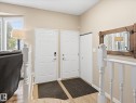 Entryway featuring wood-finish flooring, white paneled doors, and a staircase with white balusters - 18627 62A Avenue, Edmonton, AB  - Indoor Photo Showing Other Room 
