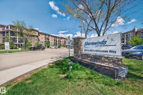 Stone-clad monument sign for Shorewinds Schonee Condominiums, featuring a multi-story building with balconies and exterior lighting - 340 6076 Schonsee Way, Edmonton, AB - Outdoor