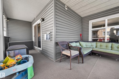 Covered outdoor patio area featuring gray horizontal siding, a white ceiling with visible joists, and a textured concrete-finish floor - 340 6076 Schonsee Way, Edmonton, AB - Outdoor With Exterior