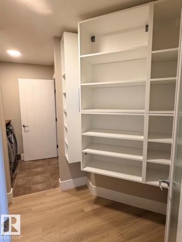 Built-in white cabinetry with adjustable shelving and a separate enclosed cabinet - 648 178 Street, Edmonton, AB - Indoor With Storage