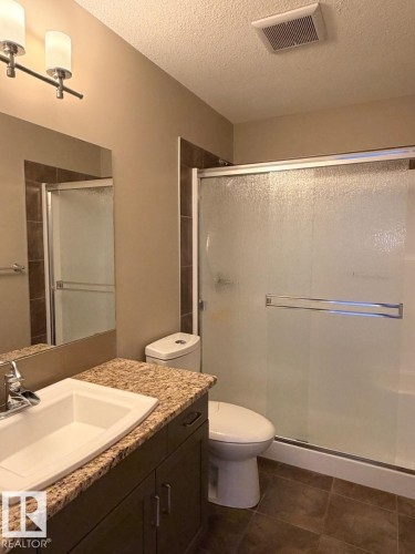 Bathroom featuring a vanity with a light-toned countertop, a rectangular sink, and a chrome faucet - 648 178 Street, Edmonton, AB - Indoor Photo Showing Bathroom