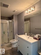 Bathroom featuring a white vanity with integrated sink, chrome faucet, and mosaic tile backsplash - 