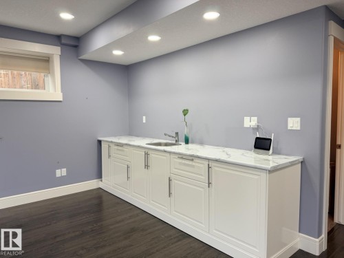 Built-in lower cabinetry with a white finish and contemporary hardware, complemented by a marble-look countertop and an integrated stainless steel sink - 648 178 Street, Edmonton, AB - Indoor Photo Showing Other Room