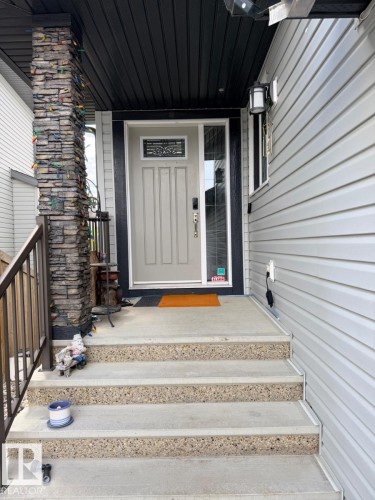 Front entry featuring a light-colored main door with decorative glass inlay and a sidelight - 648 178 Street, Edmonton, AB - Outdoor With Exterior