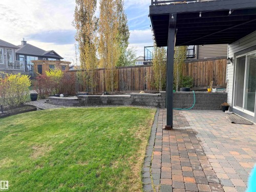 Backyard featuring a paver patio, established lawn, and multi-level retaining walls - 648 178 Street, Edmonton, AB 