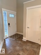 Entryway featuring a white door with decorative glass, a sidelight, and square ceramic tile flooring - 