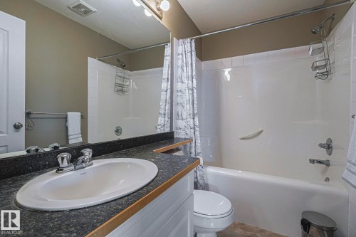 Full bathroom featuring a single vanity with a dark countertop, an oval undermount sink, and a chrome faucet - 314 5340 199 Street, Edmonton, AB - Indoor Photo Showing Bathroom