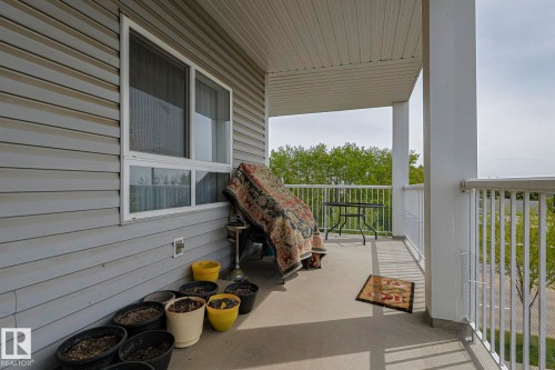 Spacious covered balcony featuring a concrete surface, white railing, and exterior siding - 314 5340 199 Street, Edmonton, AB - Outdoor With Exterior
