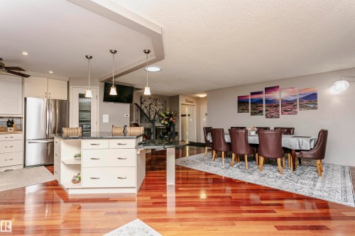 The property features an open-concept layout with gleaming hardwood floors throughout the living and dining areas - 9831 185 Street, Edmonton, AB - Indoor