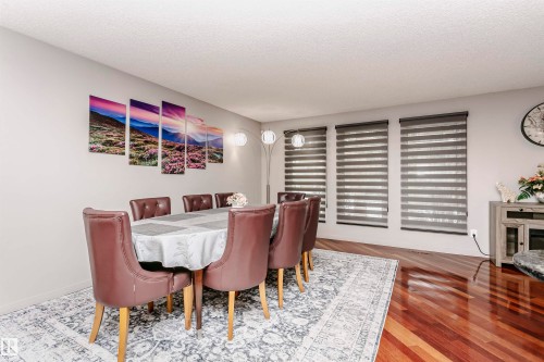 The property features rich hardwood flooring and large windows with horizontal blinds - 9831 185 Street, Edmonton, AB - Indoor Photo Showing Dining Room