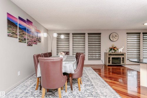 The dining area features rich hardwood flooring and a decorative area rug - 9831 185 Street, Edmonton, AB - Indoor