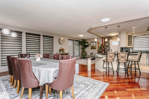 Expansive living area featuring rich hardwood flooring and numerous windows with horizontal blinds, providing ample natural light - 9831 185 Street, Edmonton, AB - Indoor Photo Showing Dining Room