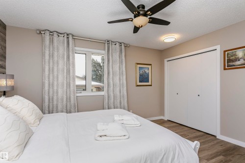 Bedroom featuring a window with patterned drapes, a ceiling fan, and light-colored flooring - 9831 185 Street, Edmonton, AB - Indoor Photo Showing Bedroom