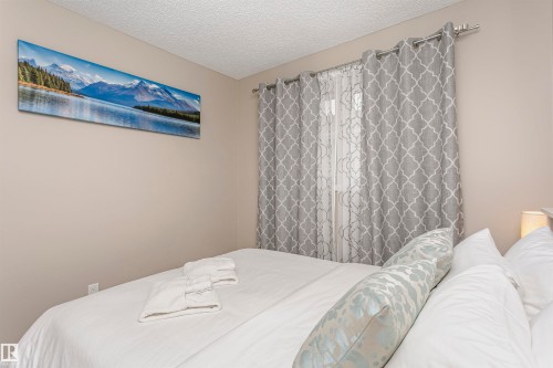 This bedroom features light-colored walls and patterned curtains - 9831 185 Street, Edmonton, AB - Indoor Photo Showing Bedroom