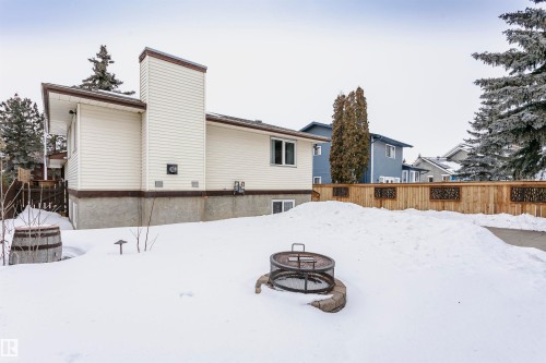 The property features a private yard with a wooden fence and a fire pit - 9831 185 Street, Edmonton, AB - Outdoor