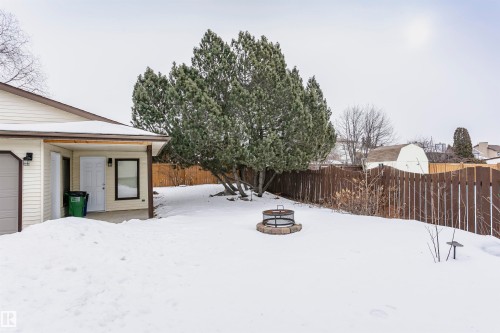 The property features a fenced yard, a fire pit, and mature trees - 9831 185 Street, Edmonton, AB - Outdoor