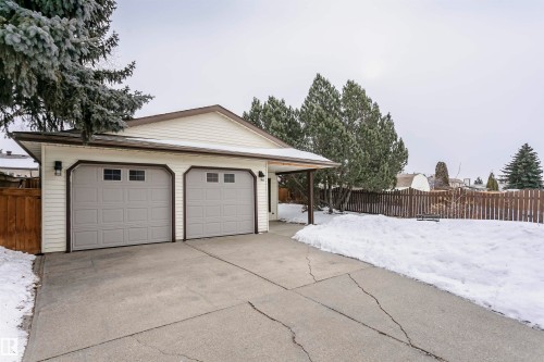 The property features a two-car garage with panelled doors and window inserts, and a concrete driveway - 9831 185 Street, Edmonton, AB - Outdoor
