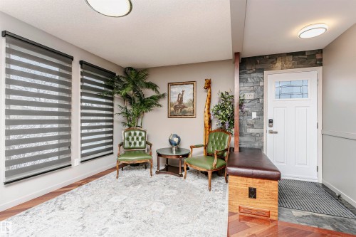 Entryway featuring a white door with a window, stone accent wall, and wood flooring - 9831 185 Street, Edmonton, AB - Indoor Photo Showing Other Room