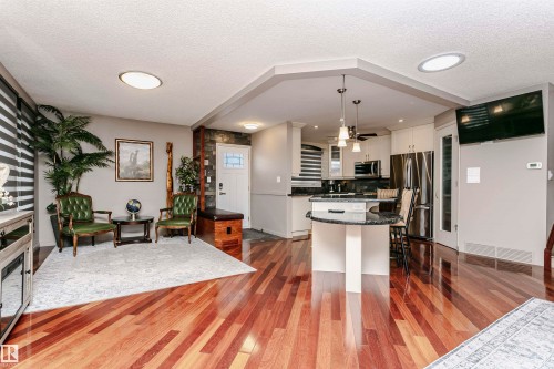 Open concept living space featuring hardwood floors, recessed lighting, and a modern kitchen with a center island - 9831 185 Street, Edmonton, AB - Indoor