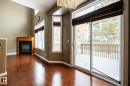 Doorway to outside featuring a glass covered fireplace and hardwood / wood-style flooring - 11622 11 Avenue, Edmonton, AB  - Indoor With Fireplace 