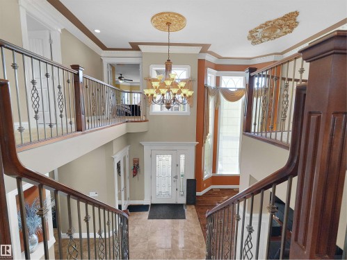 Grand entryway featuring a decorative double-door entry with frosted glass, marble-look tile flooring, and a two-story ceiling - 1511 69 Street, Edmonton, AB - Indoor Photo Showing Other Room