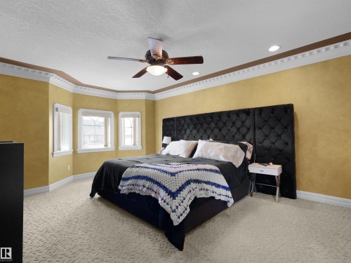 Spacious bedroom featuring patterned carpeting, a multi-window bay area, crown molding, a ceiling fan, and recessed lighting - 1511 69 Street, Edmonton, AB - Indoor Photo Showing Bedroom