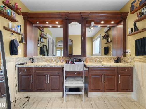 Dual vanity with rich wood cabinetry, stone countertops, and integrated sinks - 1511 69 Street, Edmonton, AB - Indoor Photo Showing Bathroom